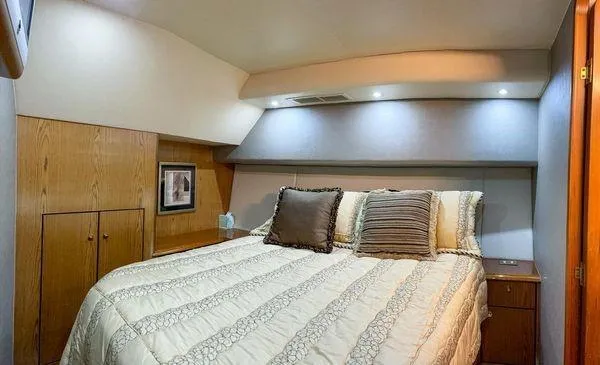 No Name Yacht Photos Pics Luxurious bedroom interior of 2008 Ocean Yachts 46SS with cozy bedding and wooden accents.