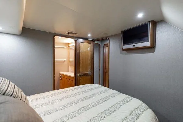 No Name Yacht Photos Pics Interior of 2008 Ocean Yachts 46SS, featuring a cozy bedroom with TV and wooden accents.