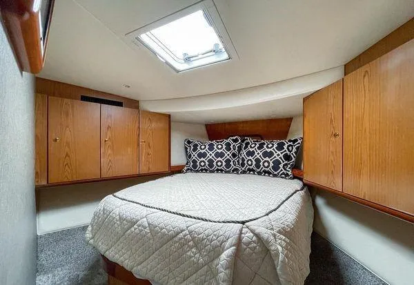 No Name Yacht Photos Pics Luxurious cabin interior of 2008 Ocean Yachts 46SS with cozy bed and wooden cabinets.