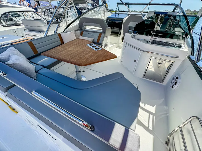  Yacht Photos Pics 2024 Beneteau Flyer 10 boat interior with seating, table, and helm station.