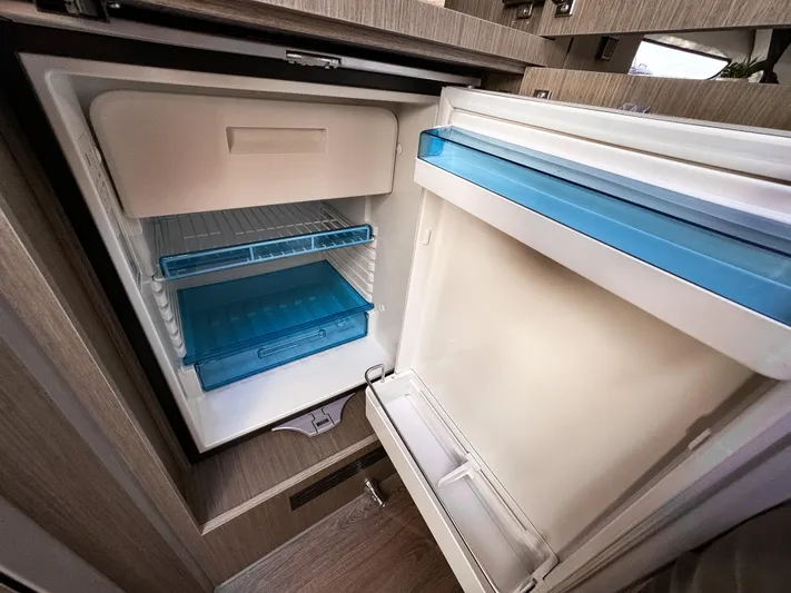  Yacht Photos Pics 2024 Beneteau Flyer 10 interior fridge with open door and blue shelves.