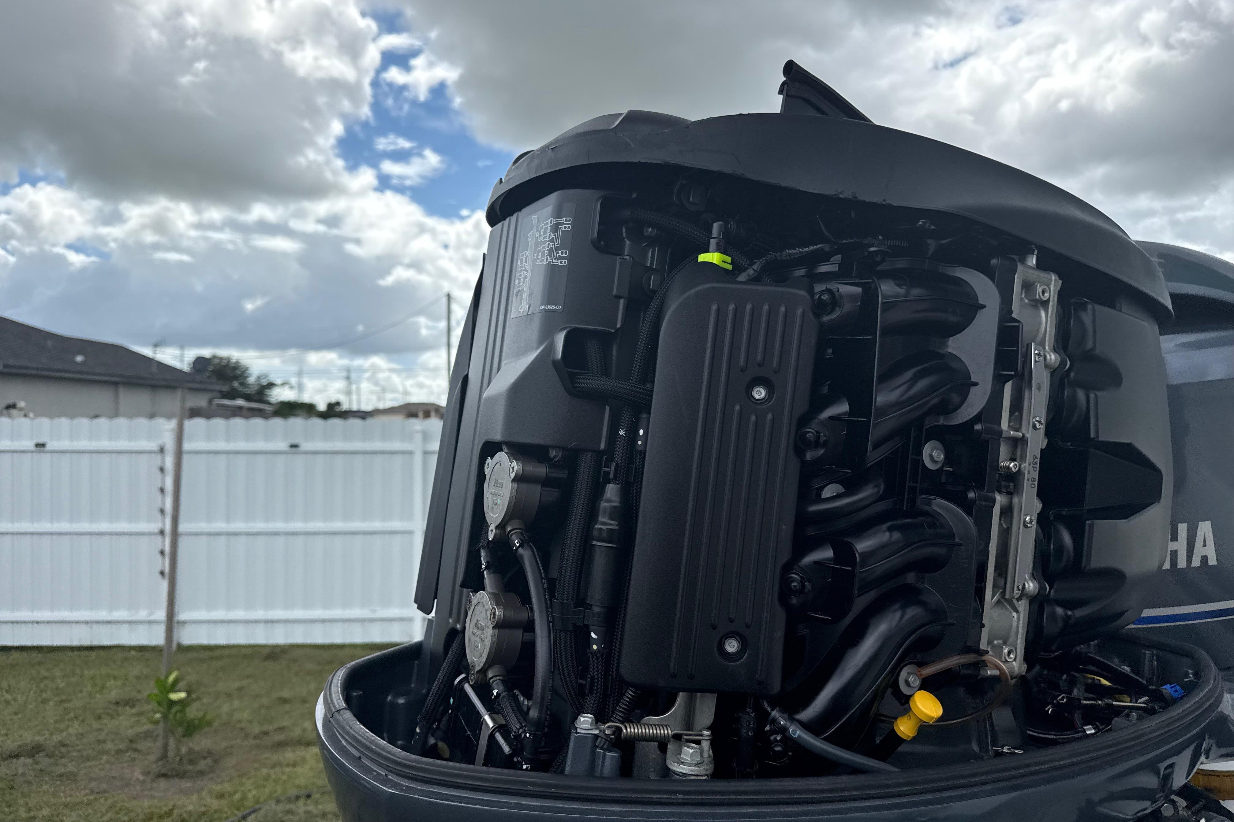 Close-up of a Yamaha outboard motor, showcasing engine details under a cloudy sky.