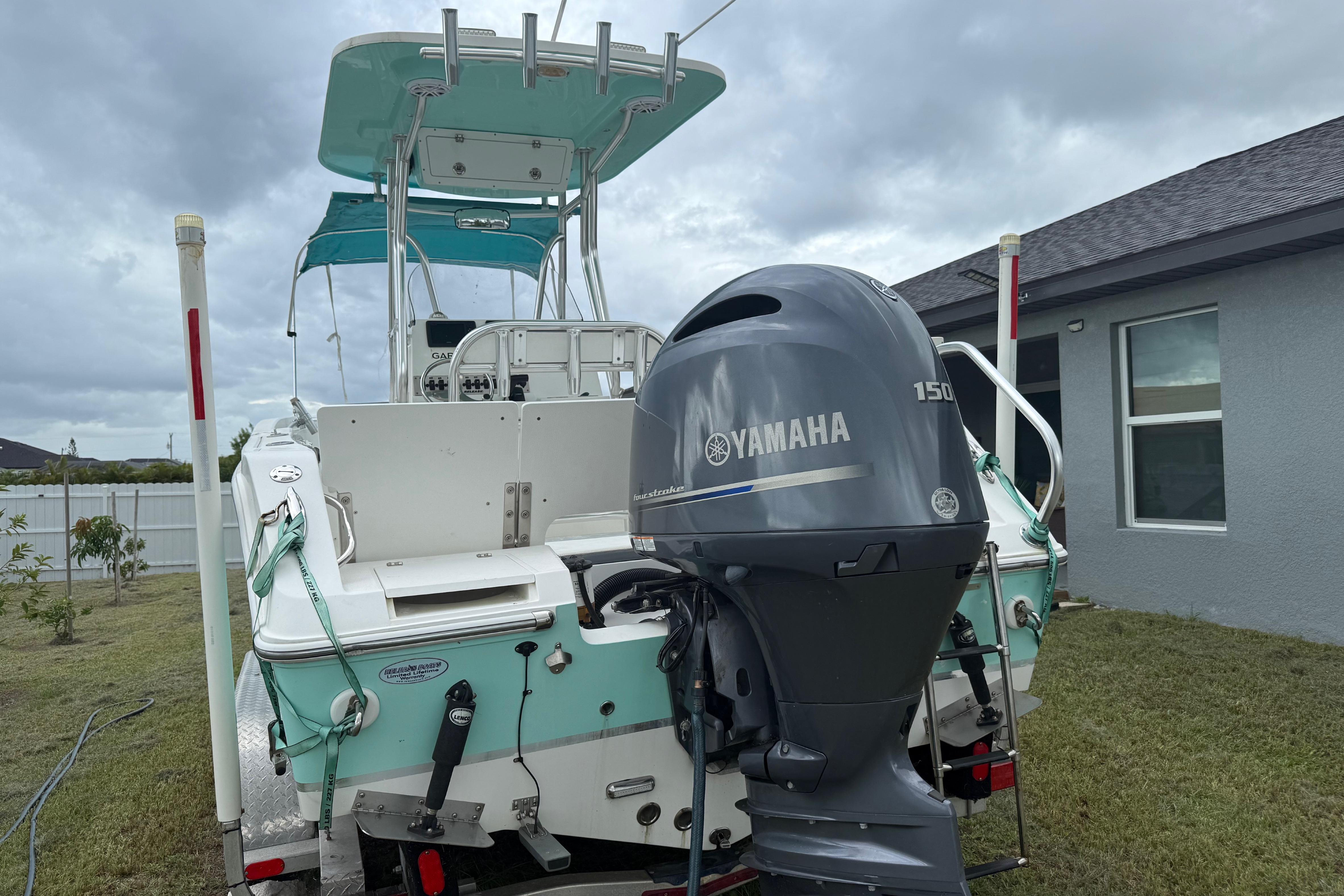 2018 Release 208 RX boat with Yamaha 150 engine, parked in a residential yard.