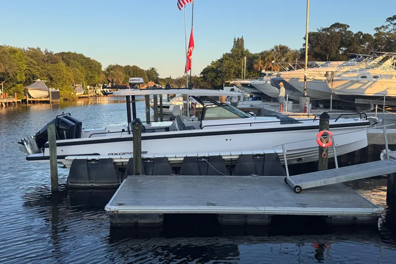 Axopar 37 Suntop Yacht Photos Pics 2024 Axopar 37 SunTop boat docked at marina with scenic background.