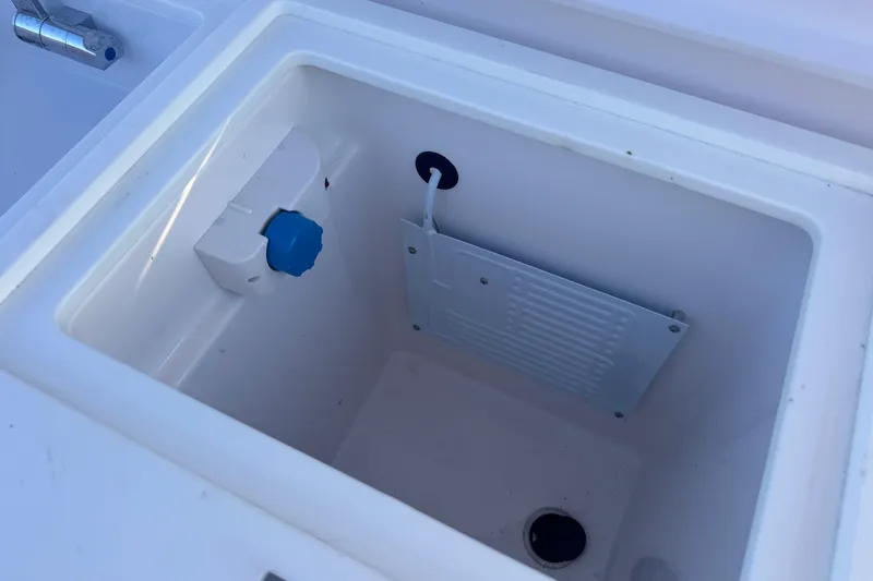 Axopar 37 Suntop Yacht Photos Pics 2024 Axopar 37 SunTop boat cooler compartment with drain and blue knob.