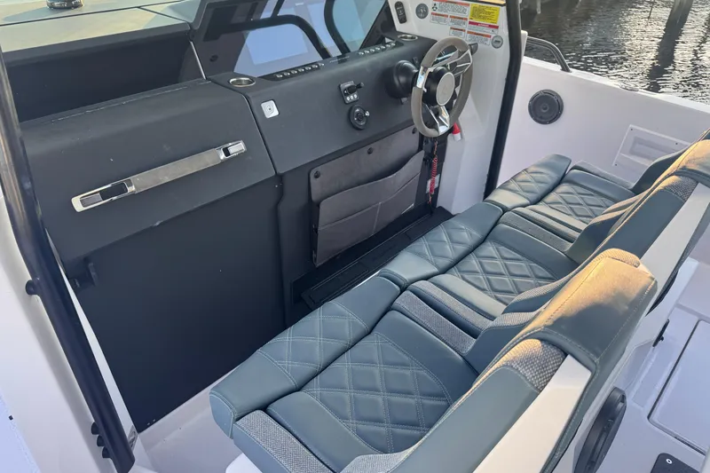 Axopar 37 Suntop Yacht Photos Pics 2024 Axopar 37 SunTop cockpit with modern steering and quilted seating.