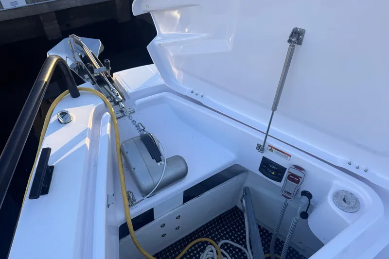 Axopar 37 Suntop Yacht Photos Pics 2024 Axopar 37 SunTop boat anchor compartment with open hatch and equipment.