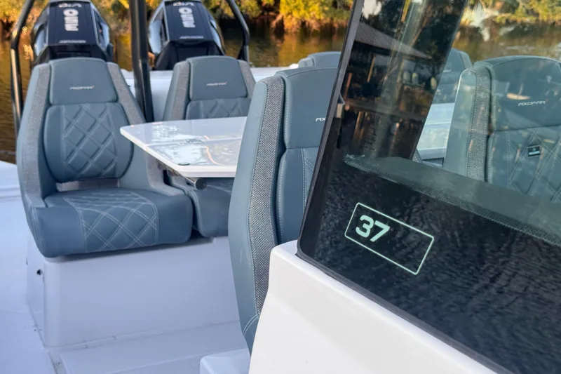 Axopar 37 Suntop Yacht Photos Pics 2024 Axopar 37 SunTop boat interior with seating and table, featuring modern design.