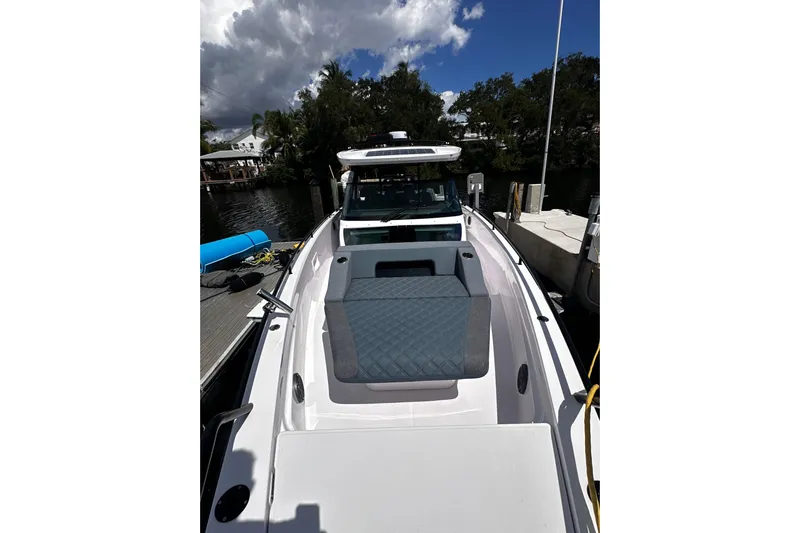 Axopar 37 Suntop Yacht Photos Pics 2024 Axopar 37 SunTop boat docked, featuring sleek design and spacious seating.