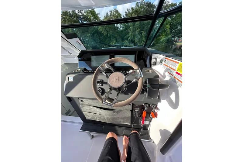 Axopar 37 Suntop Yacht Photos Pics 2024 Axopar 37 SunTop helm with steering wheel and control panel.