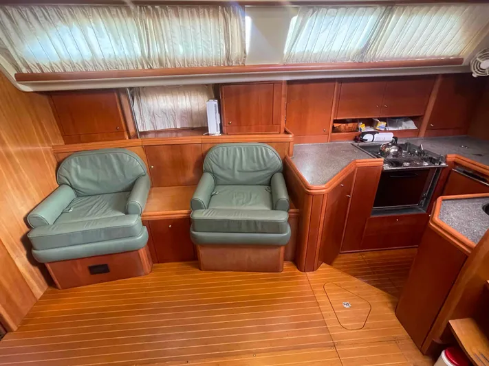 Gratitude Yacht Photos Pics Interior of 1999 Moody 46 CC yacht with green chairs and wooden cabinetry.