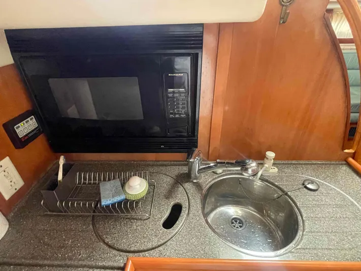 Gratitude Yacht Photos Pics Compact kitchen area in a 1999 Moody 46 CC yacht with microwave and sink.