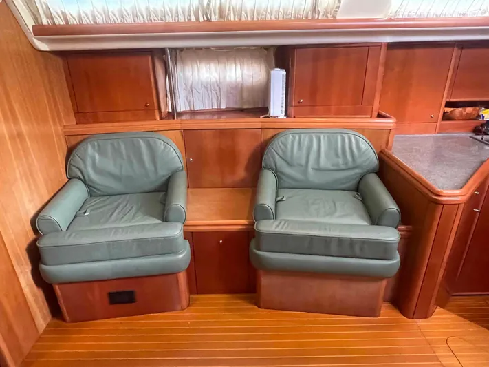 Gratitude Yacht Photos Pics Luxurious interior of 1999 Moody 46 CC yacht with green leather chairs and wooden cabinetry.