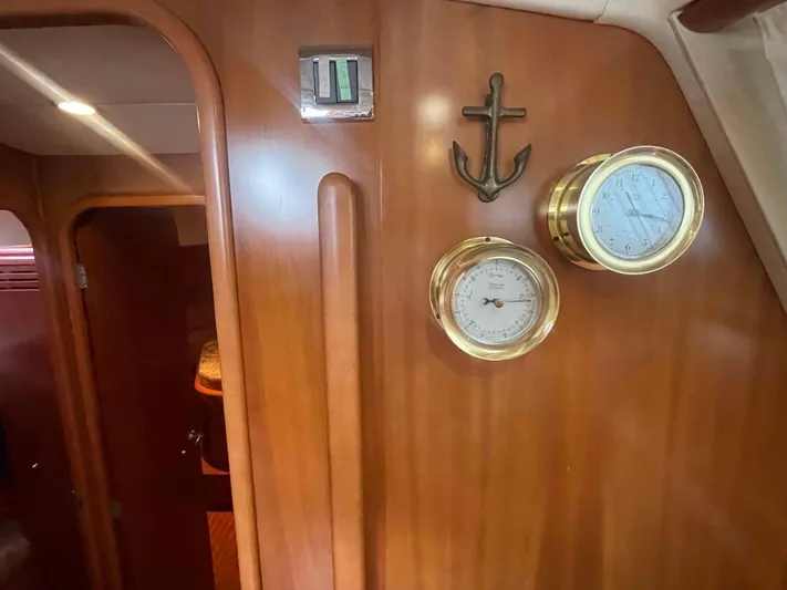 Gratitude Yacht Photos Pics Wooden interior of 1999 Moody 46 CC yacht with brass instruments and anchor decor.