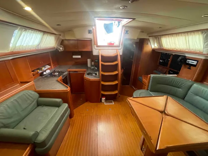 Gratitude Yacht Photos Pics 1999 Moody 46 CC yacht interior with wood finish, seating, and kitchen area.