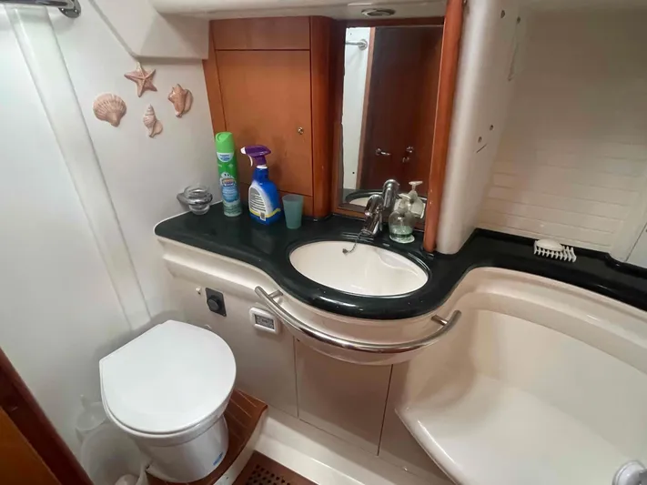 Gratitude Yacht Photos Pics Bathroom interior of 1999 Moody 46 CC yacht with sink, toilet, and cleaning supplies.