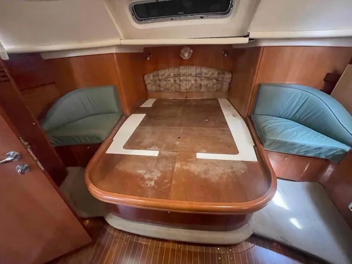 Gratitude Yacht Photos Pics 1999 Moody 46 CC yacht interior with wooden table and cushioned seating.