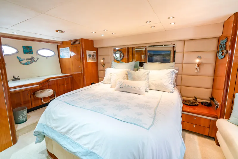 Island Girl Yacht Photos Pics Luxurious bedroom interior of 2002 Sunseeker Predator 68 yacht with elegant bedding and wood accents.