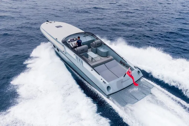  Yacht Photos Pics Sleek 2003 Magnum 44 speedboat cruising on open water, rear view.