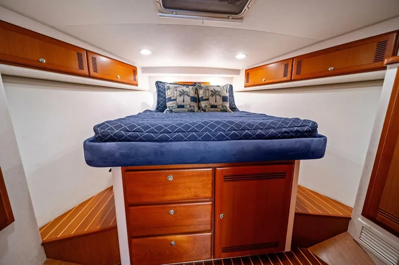 Miss B Havin Yacht Photos Pics Luxurious cabin interior of 2005 Cabo 40 Express yacht with cozy bed and wooden cabinetry.