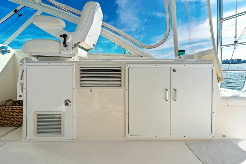 Miss B Havin Yacht Photos Pics 2005 Cabo 40 Express boat interior with white captain's chair and storage cabinets.