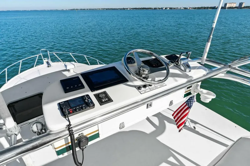 Miss B Havin Yacht Photos Pics Helm of 2005 Cabo 40 Express boat with ocean view and American flag.