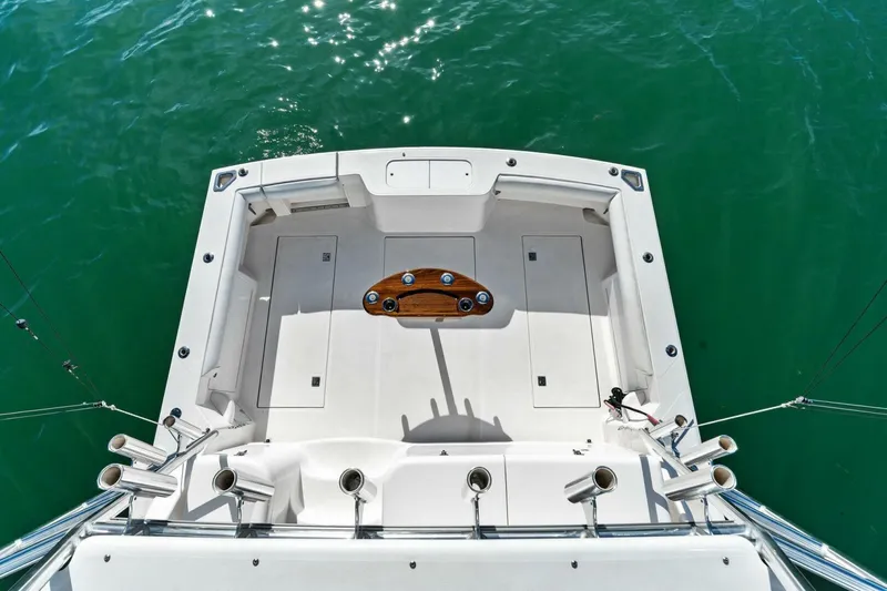 Miss B Havin Yacht Photos Pics 2005 Cabo 40 Express boat deck with fishing rod holders on calm water.