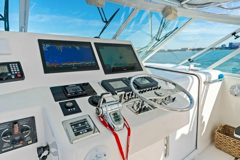 Miss B Havin Yacht Photos Pics Helm of 2005 Cabo 40 Express yacht with navigation screens and controls, overlooking ocean.
