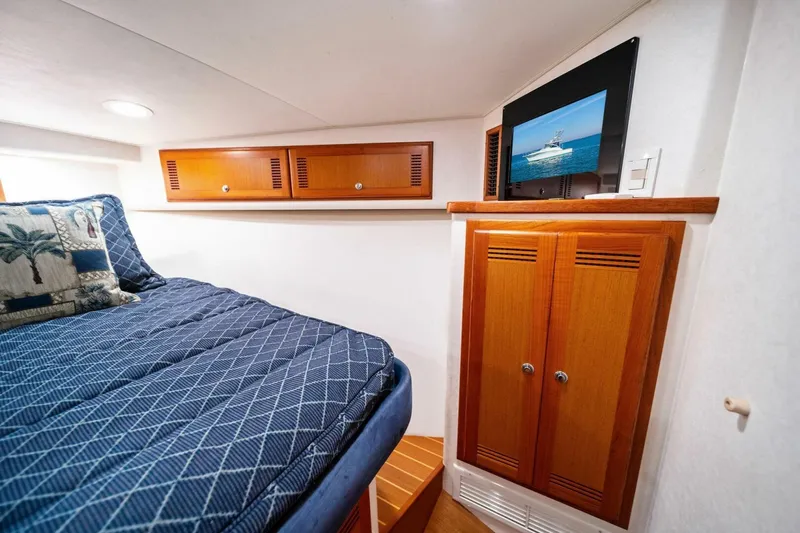 Miss B Havin Yacht Photos Pics Luxurious cabin interior of 2005 Cabo 40 Express yacht with cozy bedding and wooden cabinetry.