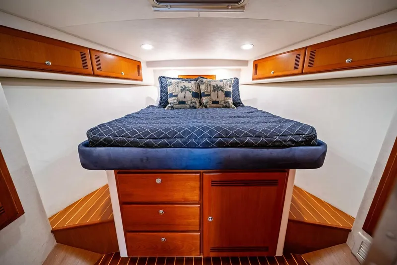 Miss B Havin Yacht Photos Pics Luxurious cabin interior of 2005 Cabo 40 Express yacht with cozy bed and wooden storage.