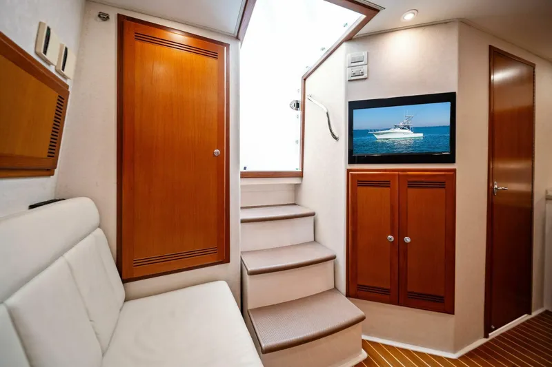 Miss B Havin Yacht Photos Pics Interior of 2005 Cabo 40 Express yacht with stairs, TV, and wooden cabinets.
