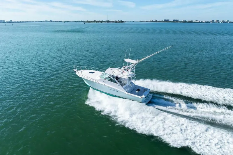 Miss B Havin Yacht Photos Pics 2005 Cabo 40 Express yacht cruising on open water, creating a wake.