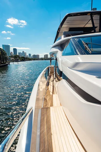  Yacht Photos Pics 2023 Ferretti Yachts 860 cruising on a sunny waterfront with city skyline.