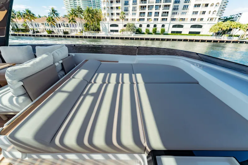  Yacht Photos Pics Luxurious sunbathing area on 2023 Ferretti Yachts 860, overlooking waterfront cityscape.