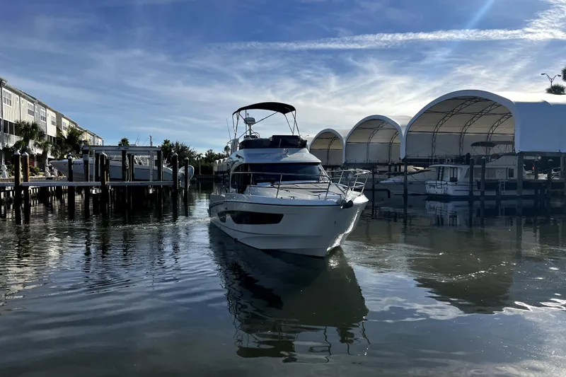  Yacht Photos Pics 2023 Beneteau Antares 11 Fly yacht docked in a marina under a clear blue sky.
