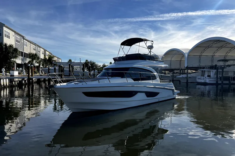  Yacht Photos Pics 2023 Beneteau Antares 11 Fly yacht docked in a marina under a clear blue sky.