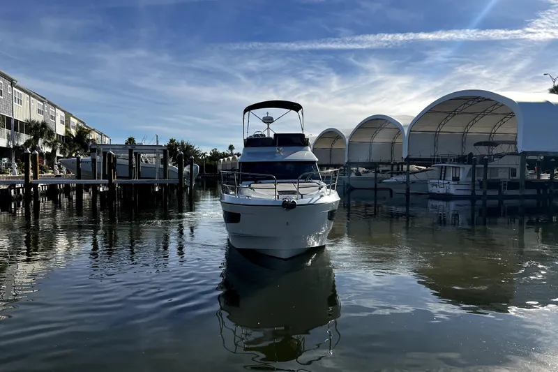  Yacht Photos Pics 2023 Beneteau Antares 11 Fly yacht docked in a marina under a clear blue sky.