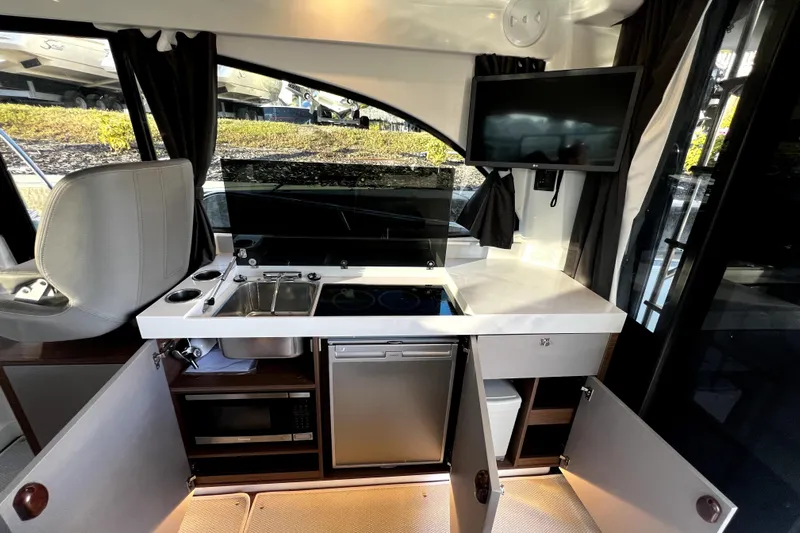  Yacht Photos Pics Modern kitchen area in 2023 Beneteau Antares 11 Fly yacht with appliances and storage.