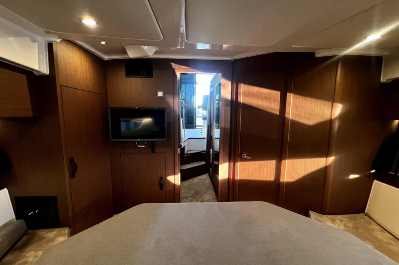  Yacht Photos Pics Interior of 2023 Beneteau Antares 11 Fly, featuring modern wood paneling and a mounted TV.