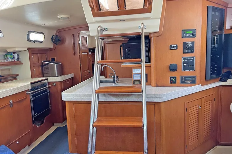  Yacht Photos Pics 2005 Island Packet 485 yacht interior with wooden cabinetry, kitchen, and ladder access.