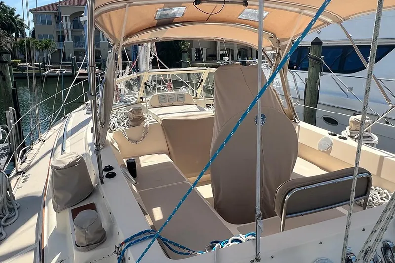  Yacht Photos Pics 2005 Island Packet 485 sailboat cockpit with beige canopy and seating, docked at marina.
