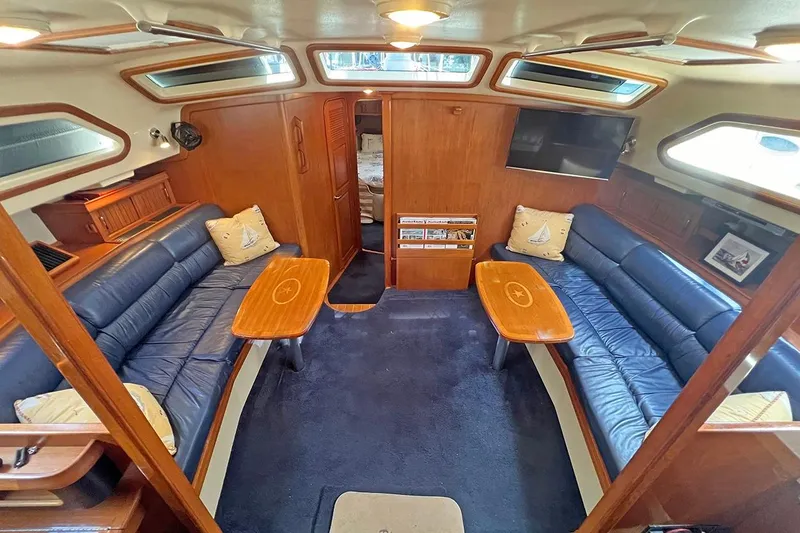  Yacht Photos Pics Luxurious 2005 Island Packet 485 yacht interior with blue leather seating and wooden accents.