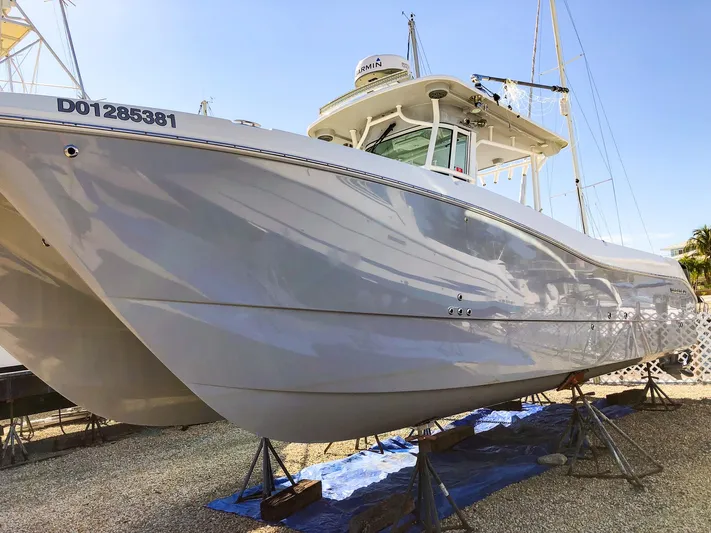  Yacht Photos Pics 2018 World Cat 320 CC boat on stands, viewed from the side under clear blue sky.