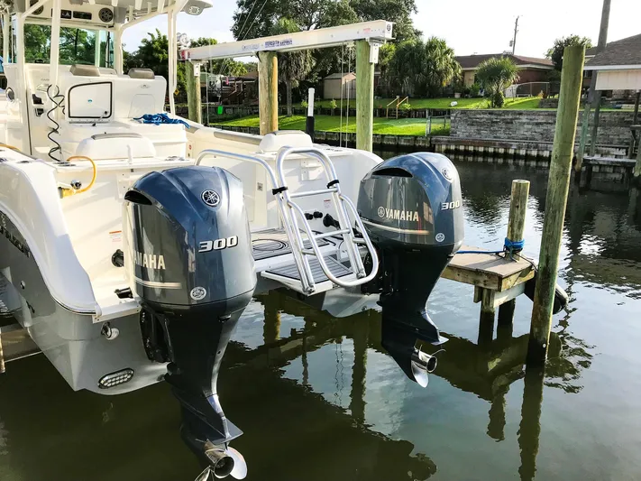  Yacht Photos Pics 2018 World Cat 320 CC with twin Yamaha 300 engines docked by water.