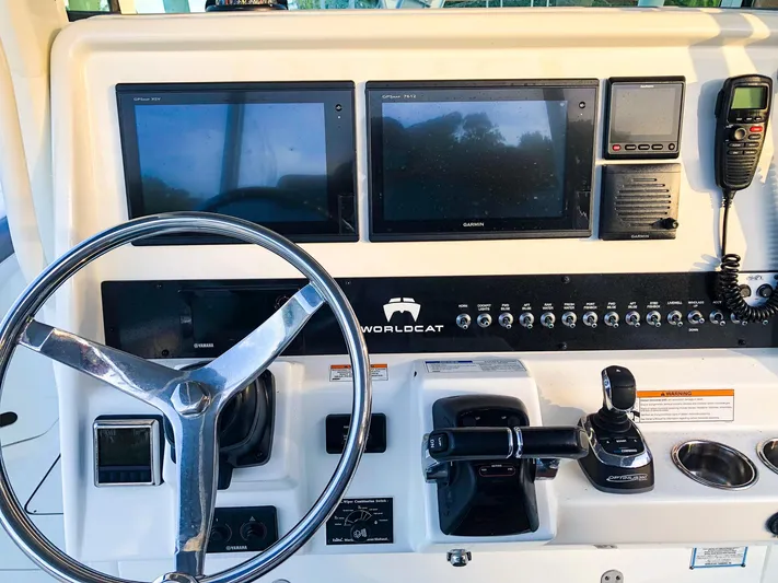  Yacht Photos Pics Control panel of 2018 World Cat 320 CC boat with steering wheel and navigation screens.