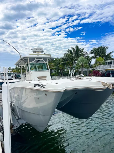  Yacht Photos Pics 2018 World Cat 320 CC boat docked by tropical waterfront under cloudy sky.