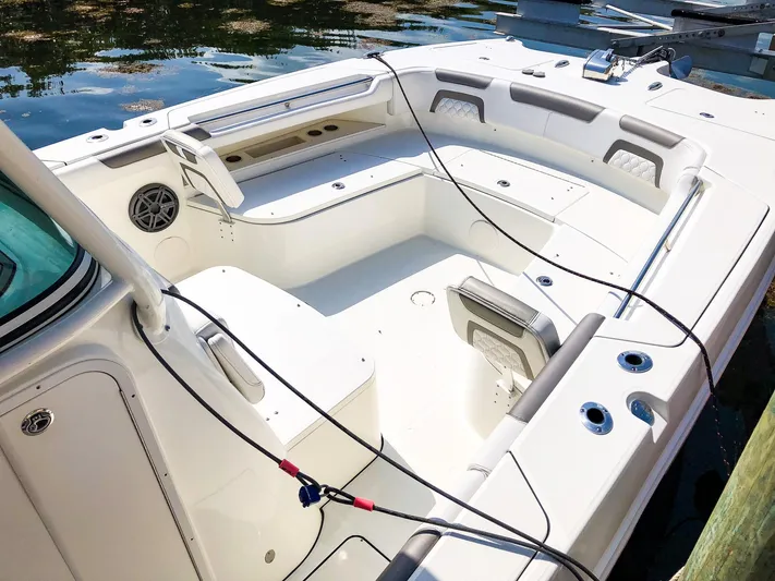  Yacht Photos Pics 2018 World Cat 320 CC boat interior with seating and storage, docked on calm water.