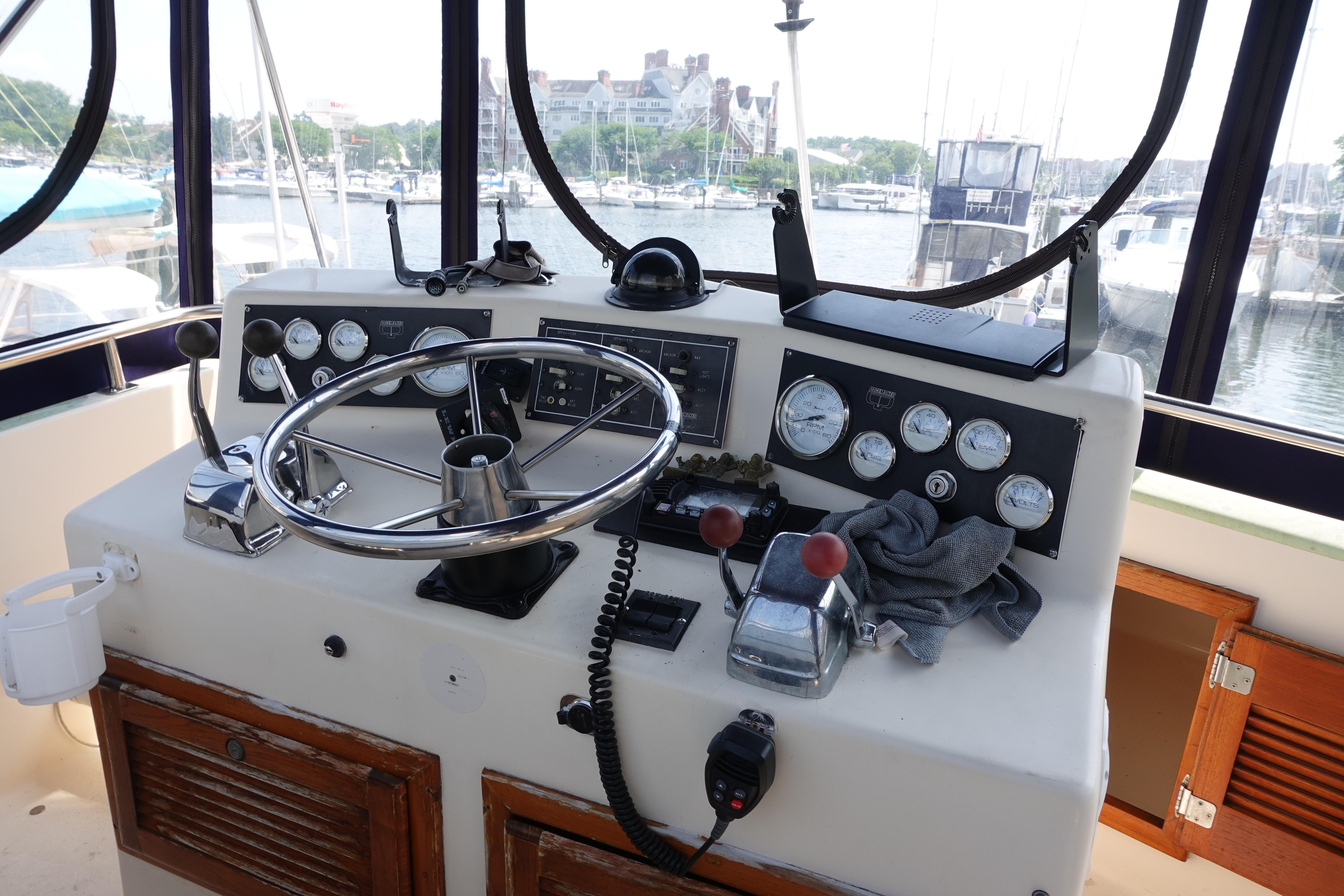 1988 Pacemaker 308 boat helm with steering wheel and control gauges at marina.