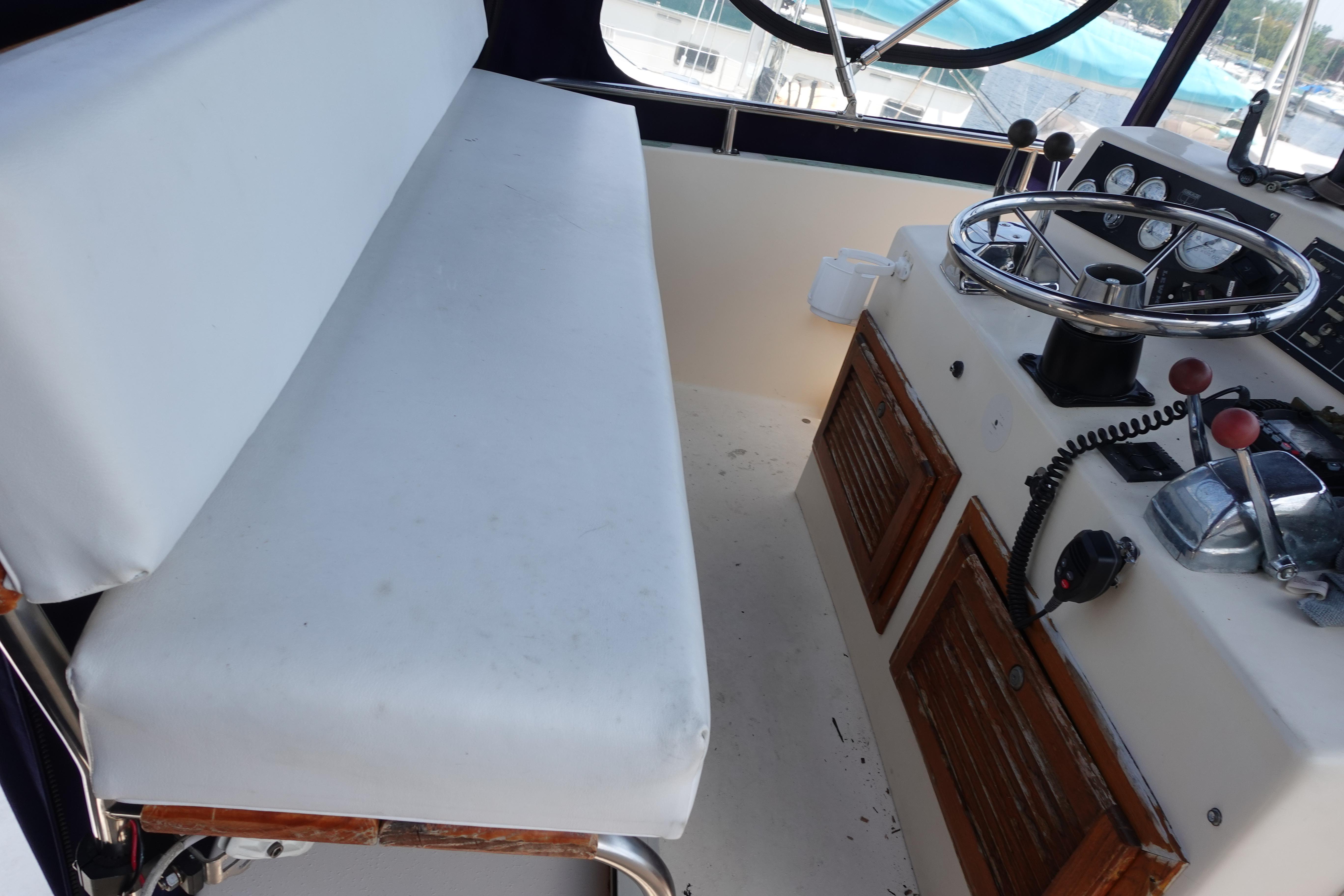 1988 Pacemaker 308 boat helm with steering wheel, controls, and cushioned bench seat.