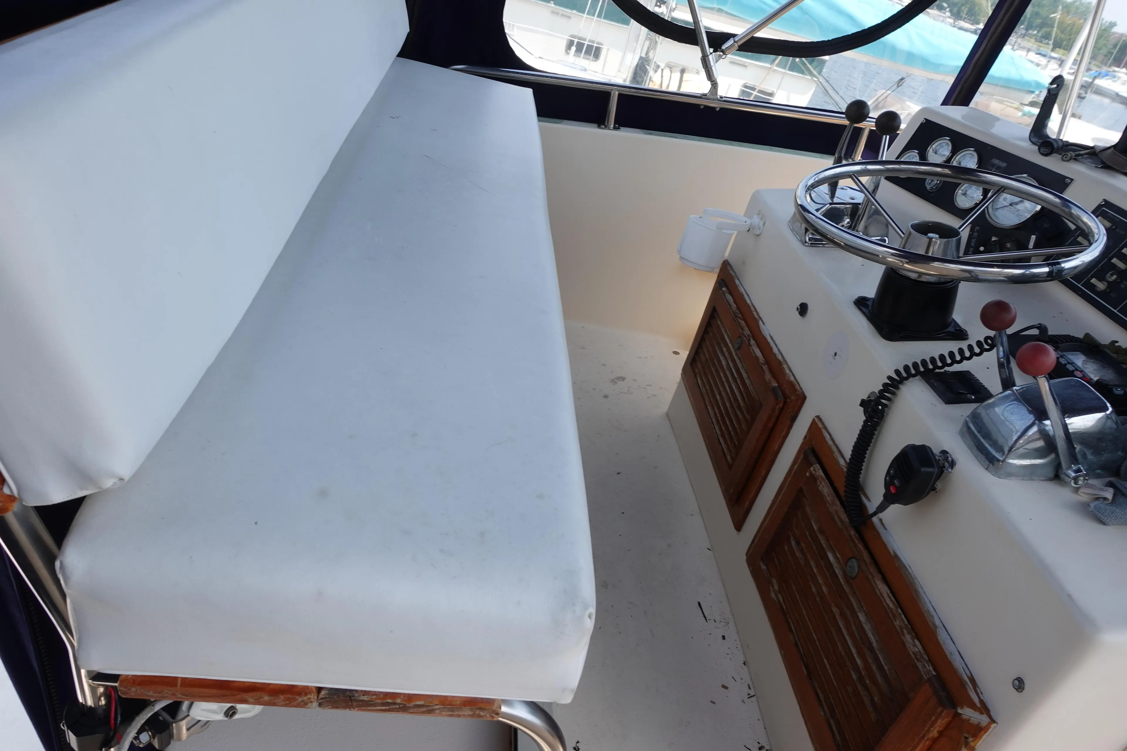 1988 Pacemaker 308 boat helm with steering wheel, controls, and cushioned bench seat.